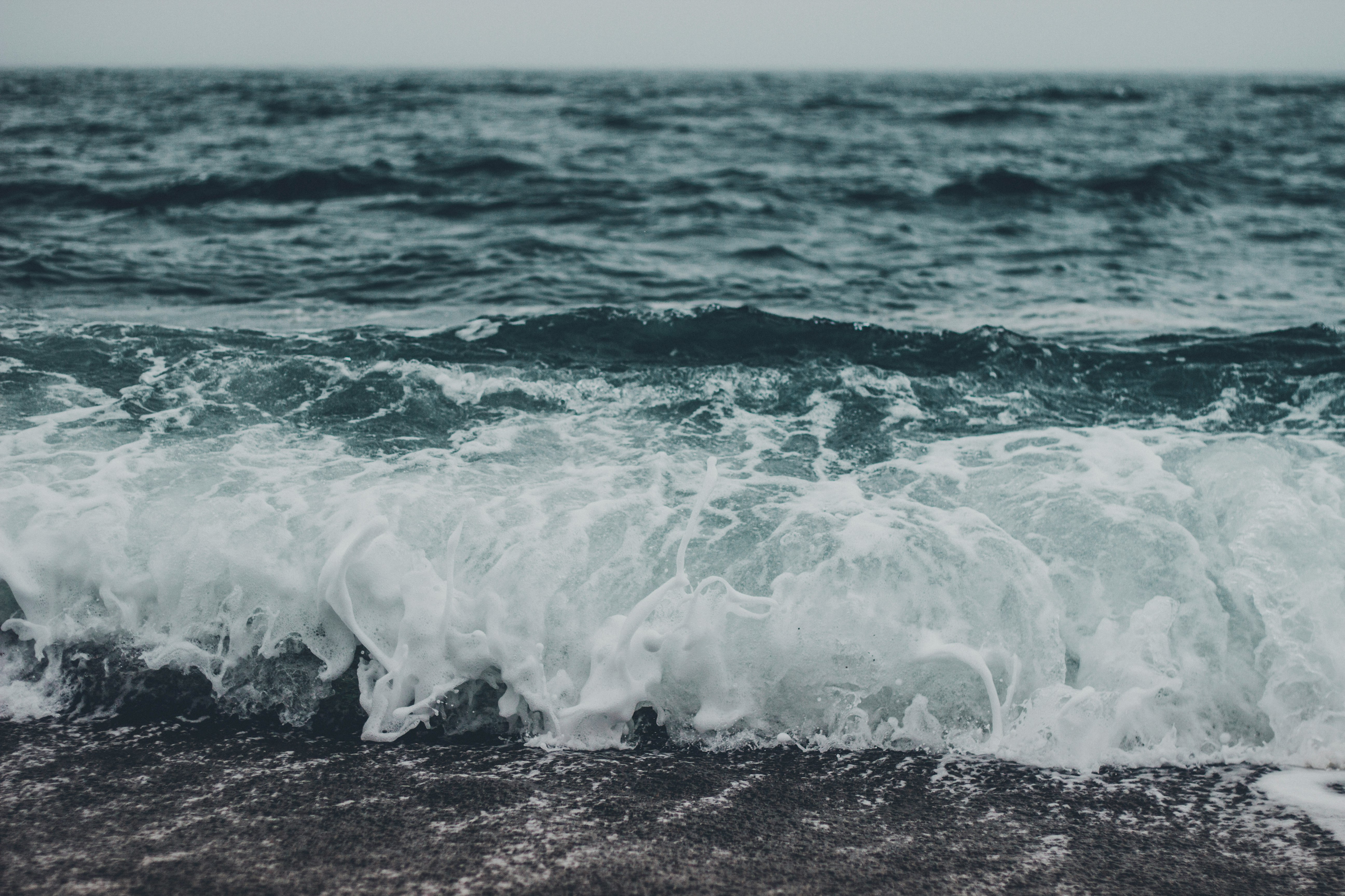 ocean waves crashing on shore during daytime